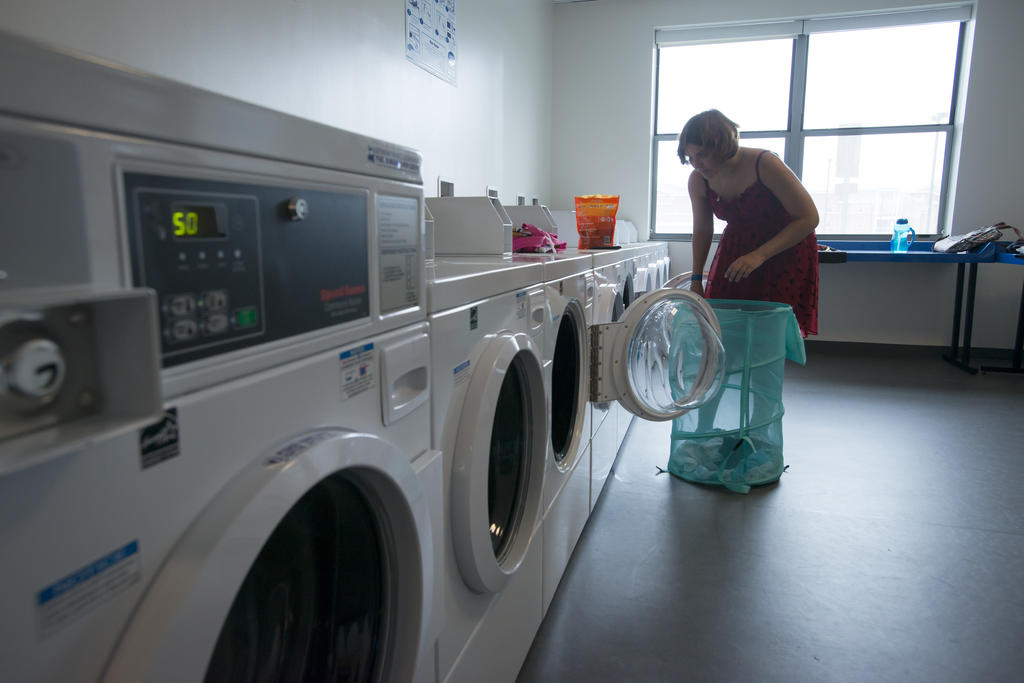 Student puts laundry into machine in Mason residence hall